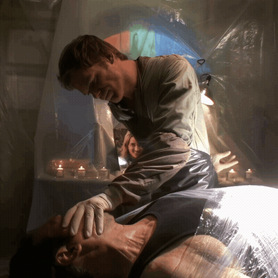 Man Lying On Table With Candles GIF