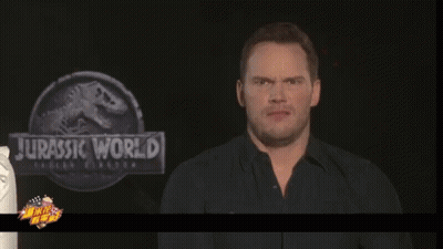 Man Making Face In Front Of Jurassic World Sign GIF