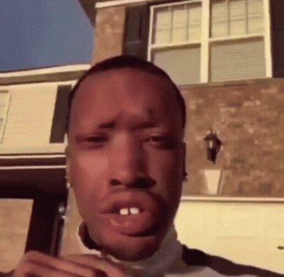 Man Making Funny Face In Front Of Brick Building GIF