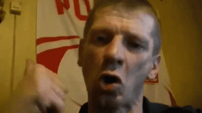 Man Making Funny Face In Front Of Flag Wall GIF