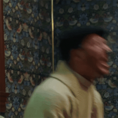Man Making Funny Face In Front Of Patterned Wallpaper GIF