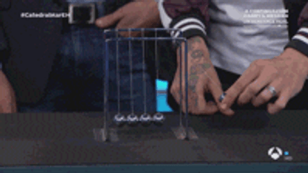 Man Making Newton Pendulum Move GIF