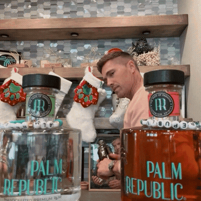 Man Next To Two Palm Republic Bottles GIF