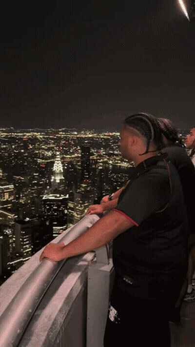 Man On Balcony Overlooking City At Night GIF