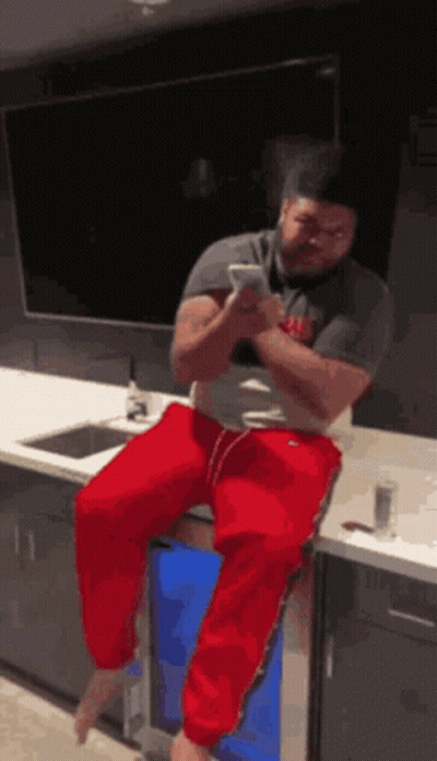 Man On Bar Stool Looking At Phone GIF