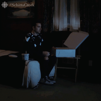 Man On Bed With Schitts Creek Box GIF