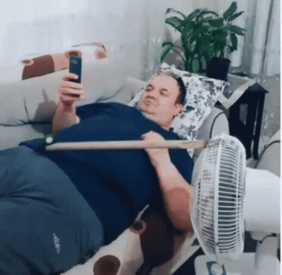 Man On Bed With Stick Looking At Phone GIF