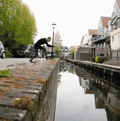 Man On Brick Wall Next To River GIF