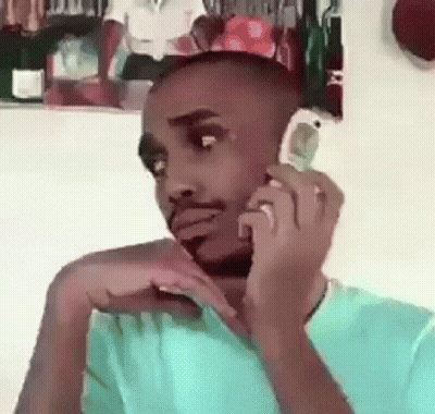 Man On Cell Phone In Front Of Man's Picture GIF