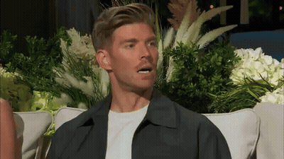 Man On Couch Making Funny Face With Flowers GIF