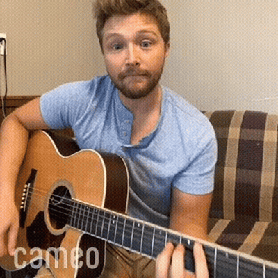 Man On Couch Playing Acoustic Guitar With Cameo Text GIF