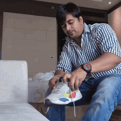 Man On Couch Tying Shoe With Rolex Watch GIF