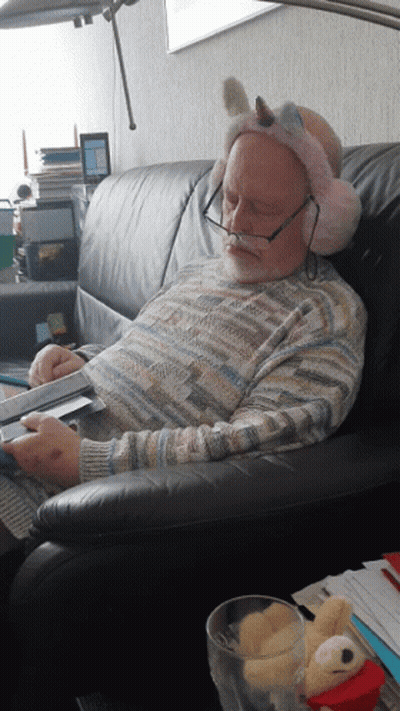 Man On Couch With Ear Muffs Unicorn Headband GIF