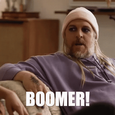 Man On Couch With Long Hair And Beanie Says Boomer GIF