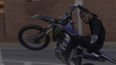 Man On Dirt Bike Doing Handstand In Front Of Stop Sign GIF