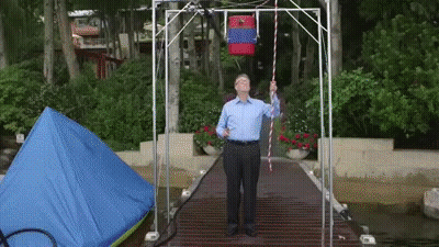 Man On Dock Holding Rope With Red Bag GIF