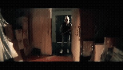 Man On Phone Holding Baseball Bat In Dark Room GIF