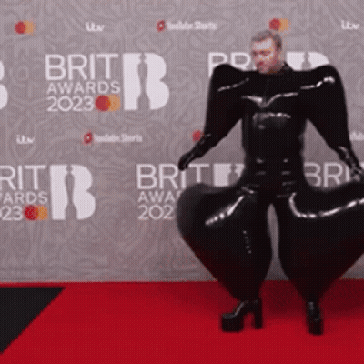 Man On Red Carpet In Front Of Brit Awards Wall GIF
