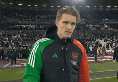 Man on Soccer Field Wearing Arsenal Jacket