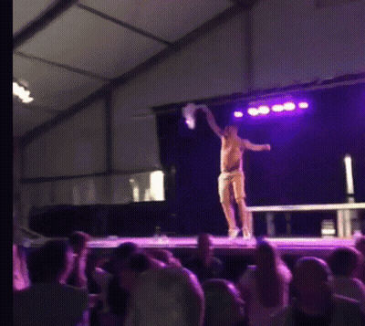 Man On Stage Holding Purple Object GIF