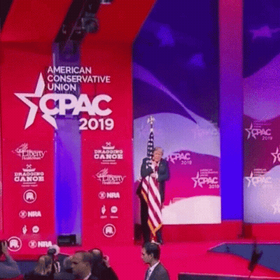 Man On Stage In Front Of American Conservative Union 2019 Sign GIF