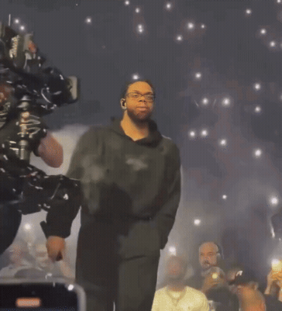 Man On Stage With Crowd Holding Phones GIF