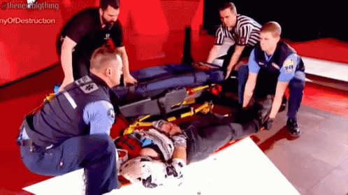 Man On Stretcher Helped By Group Of Men GIF