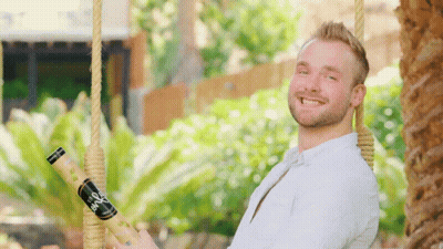Man On Swing Holding Bio Bottle GIF