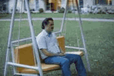 Man On Swing In Park With Eyes Closed GIF