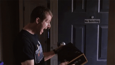 Man Opening Box In Front Of No Soliciting Sign GIF