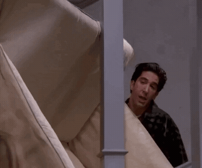 Man Peeking Behind Couch Says Pivot GIF