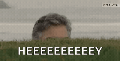 Man Peeking From Behind Grassy Hill Saying Heeeeeeeey GIF