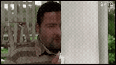 Man Peeking From Behind White Pole GIF