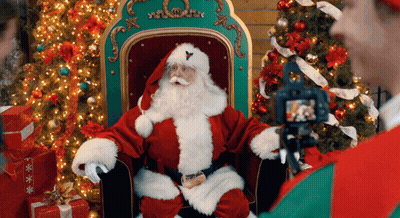 Man Photographing Santa Claus By Christmas Tree GIF