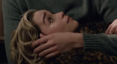 Man Placing Hand On Woman's Forehead On Couch GIF