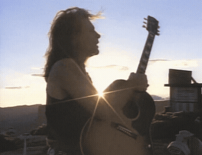 Man Playing Acoustic Guitar With Sun Shining Through