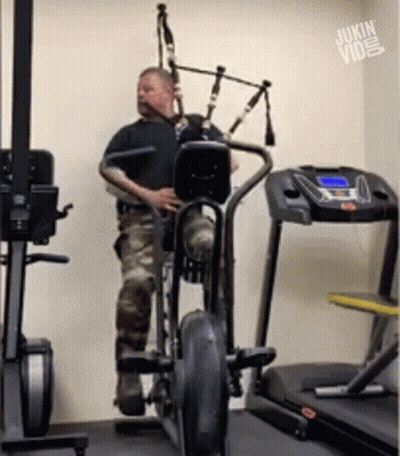 Man Playing Bagpipe On Exercise Bike GIF
