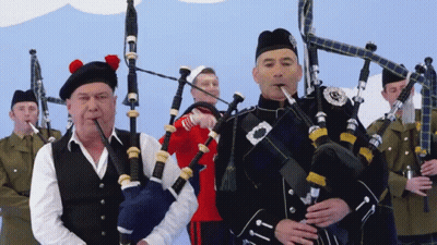Man Playing Bagpipe With Scottish Badge GIF