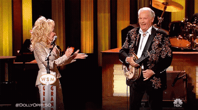 Man Playing Banjo Woman Sings Into Microphone WSM Sign GIF