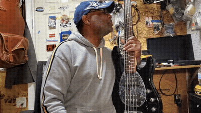 Man Playing Bass Guitar By Wall With Stihl Sticker GIF