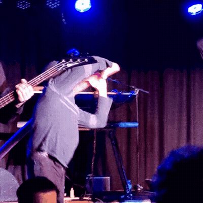 Man Playing Bass Guitar On Stage With Keyboard GIF