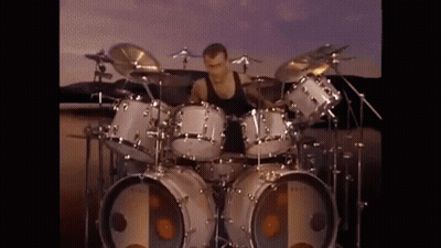 Man Playing Drum Set In Front Of Large Speaker GIF