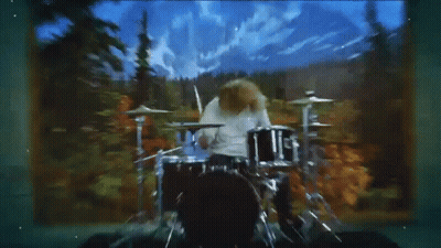 Man Playing Drum Set In Front Of Mountains GIF