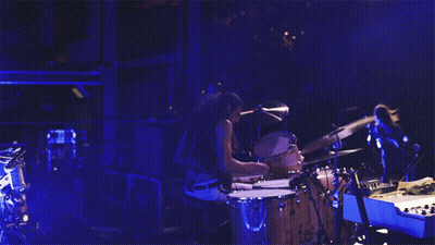 Man Playing Drums In Dark Room With Blue Light GIF