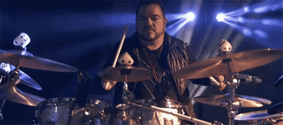Hombre tocando batería frente a luz azul GIF