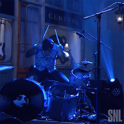 Man Playing Drums In Front Of Central Sign GIF