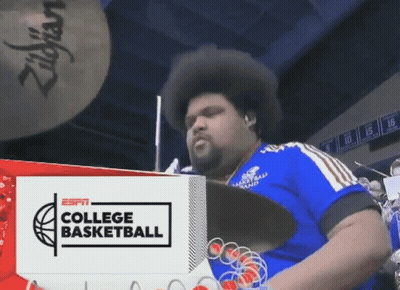 Man Playing Drums In Front Of ESPN College Basketball Ad GIF