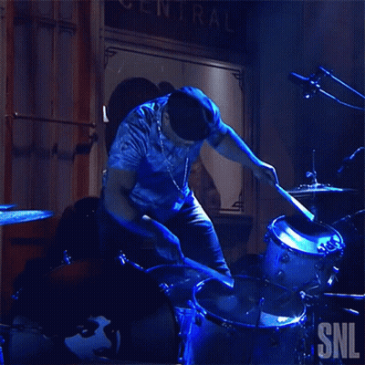 Man Playing Drums in Front of SNL Sign