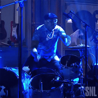 Man Playing Drums In Front Of SNL Sign GIF