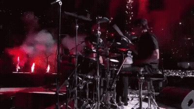 Man Playing Drums On Stage With Red Lights GIF